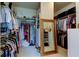 Spacious walk-in closet with ample shelving, hanging rods, and a full-length mirror, offering organized storage solutions at 2826 Riders Pass, Odessa, FL 33556