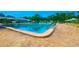 Inviting community pool with ample lounge seating and umbrellas, perfect for relaxation and recreation at 3086 Pointer Dr, Palm Harbor, FL 34683