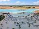 Breathtaking aerial view of a community lagoon, featuring white sand beaches, turquoise water, and resort-style amenities at 31354 Cabana Rye Ave, San Antonio, FL 33576
