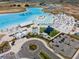 Community lagoon with beach, umbrellas, inflatables, lounge chairs, buildings and roundabout at 31354 Cabana Rye Ave, San Antonio, FL 33576