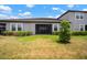 View of the home's backyard featuring a screened in porch and partial grass area at 31354 Cabana Rye Ave, San Antonio, FL 33576