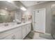 Bright bathroom with a dual sink vanity, large mirror, and neutral tile at 31354 Cabana Rye Ave, San Antonio, FL 33576