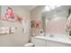 Bright bathroom featuring flamingo decor, white cabinets and vanity, plus a large mirror at 31354 Cabana Rye Ave, San Antonio, FL 33576