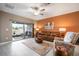 Inviting living room featuring an orange accent wall, comfortable seating, and access to an outdoor patio at 31354 Cabana Rye Ave, San Antonio, FL 33576