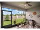 Cozy screened-in patio with a ceiling fan and decorative elements, overlooking the well-maintained backyard at 31354 Cabana Rye Ave, San Antonio, FL 33576