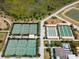 Aerial view of the community tennis courts, shuffleboard, and bocce ball courts surrounded by landscaping at 31354 Cabana Rye Ave, San Antonio, FL 33576
