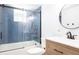 Modern bathroom with stylish blue subway tile and a round mirror at 320 Crosswinds Dr, Palm Harbor, FL 34683