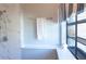 Updated bathroom featuring marble tiles, shower head, and a window with a blind at 320 Crosswinds Dr, Palm Harbor, FL 34683