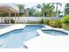 In-ground pool and spa surrounded by a concrete deck and a white vinyl fence at 320 Crosswinds Dr, Palm Harbor, FL 34683