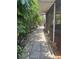 Landscaped backyard featuring a stone paver walkway surrounded by lush tropical foliage and a glimpse of the home at 3210 W North B St, Tampa, FL 33609