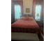 Bedroom featuring wallpaper, four-poster bed with red bedding, decorative curtains, and vintage charm at 3210 W North B St, Tampa, FL 33609