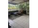 Covered patio with tiled flooring, patio furniture and a view of the fenced backyard and tropical greenery at 3210 W North B St, Tampa, FL 33609