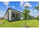 Backyard featuring a screened in patio, lush green grass, and tasteful landscaping at 3737 Nandina Cir, Sun City Center, FL 33573