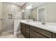 Bathroom featuring double sinks, with white countertops, a shower with gray tiles and a large mirror at 3737 Nandina Cir, Sun City Center, FL 33573