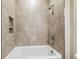 Modern bathroom showcasing a soaking tub with gray tile surround and convenient inset shelving at 3737 Nandina Cir, Sun City Center, FL 33573
