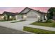 Modern townhomes featuring well-kept lawns, concrete driveways, and attached garages for convenient parking at 3737 Nandina Cir, Sun City Center, FL 33573