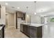 Modern kitchen with stainless appliances, island, and a seamless transition to the dining area at 3737 Nandina Cir, Sun City Center, FL 33573