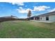 Expansive backyard with lush grass, a screened-in patio, and a privacy fence at 37437 Laurel Hammock Dr, Zephyrhills, FL 33541