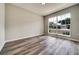 Sunlit bedroom showcasing modern plank floors and a large window with a neighborhood view at 37437 Laurel Hammock Dr, Zephyrhills, FL 33541