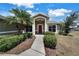 Inviting front entrance with a red front door, surrounded by manicured landscaping and a walkway at 37437 Laurel Hammock Dr, Zephyrhills, FL 33541