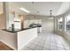 Bright kitchen with white cabinets, black countertops, tiled floors, and stainless steel appliances at 37437 Laurel Hammock Dr, Zephyrhills, FL 33541