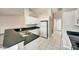 Kitchen with white cabinets, black countertops, tiled floors, and stainless steel appliances at 37437 Laurel Hammock Dr, Zephyrhills, FL 33541