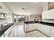 Well-lit kitchen with white cabinets, black countertops, tiled floors, and stainless steel appliances at 37437 Laurel Hammock Dr, Zephyrhills, FL 33541