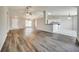 Bright living room with hardwood floors, ceiling fan, and partial view of the kitchen at 37437 Laurel Hammock Dr, Zephyrhills, FL 33541