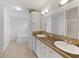 Well-lit bathroom featuring dual sinks, garden tub, and wood-look flooring at 37639 Newport Dr, Zephyrhills, FL 33542