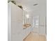 Bathroom featuring double sinks, storage, decorative mirror and a doorway to the bedroom at 37639 Newport Dr, Zephyrhills, FL 33542