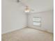 Carpeted bedroom with natural light from a window, offering a simple and versatile space for rest and relaxation at 37639 Newport Dr, Zephyrhills, FL 33542