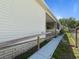Single story home with a ramp, vinyl siding, a well-maintained lawn and mature trees at 37639 Newport Dr, Zephyrhills, FL 33542