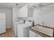 Laundry area equipped with a washing machine, dryer, sink, and plenty of storage space at 37639 Newport Dr, Zephyrhills, FL 33542