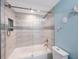 Bright bathroom featuring a tub with glass doors and updated fixtures at 404 Hammock Pine Blvd # 404, Clearwater, FL 33761