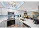 Bright kitchen with skylight boasts stainless steel appliances and pass-through to living area at 404 Hammock Pine Blvd # 404, Clearwater, FL 33761