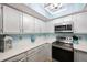 Charming kitchen with quartz countertops, stainless appliances and bright blue accent wall at 404 Hammock Pine Blvd # 404, Clearwater, FL 33761