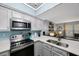 Spacious kitchen features stainless steel appliances and a breakfast bar overlooking the living area at 404 Hammock Pine Blvd # 404, Clearwater, FL 33761
