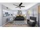 Inviting living room featuring modern ceiling fan, sleek black sofa, and view of the adjacent kitchen area at 404 Hammock Pine Blvd # 404, Clearwater, FL 33761