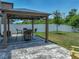 Backyard with outdoor dining area under gazebo, featuring a manicured lawn and privacy fence at 413 Royal Empress Dr, Ruskin, FL 33570