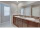 Bathroom featuring dual sinks with granite countertops and a vanity, with access to a water closet at 413 Royal Empress Dr, Ruskin, FL 33570