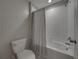Clean bathroom featuring white tiled shower-over-tub with neutral shower curtain, and a standard toilet at 413 Royal Empress Dr, Ruskin, FL 33570