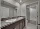 Bright bathroom features a double-sink vanity with granite countertops, and a tiled shower-over-tub at 413 Royal Empress Dr, Ruskin, FL 33570