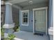Covered front porch featuring light blue siding, white trim, an olive-green front door, and a Welcome mat at 413 Royal Empress Dr, Ruskin, FL 33570
