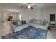 Spacious living room featuring tile floors, two sofas, ceiling fan, and bright, open access to the dining area at 413 Royal Empress Dr, Ruskin, FL 33570