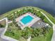 Aerial view of a community pool with palm trees and a lake view at 413 Royal Empress Dr, Ruskin, FL 33570