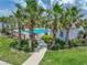 View of a community pool behind palm trees and a cement walkway at 413 Royal Empress Dr, Ruskin, FL 33570