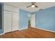 Bedroom with wooden floors, ceiling fan, and closet doors at 4330 7Th N Ave, St Petersburg, FL 33713