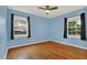 Bedroom with wood floors, blue walls, two windows with curtains for natural light at 4330 7Th N Ave, St Petersburg, FL 33713