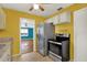 Compact eat-in kitchen with stainless steel appliances and tile floors, view into the living room at 4330 7Th N Ave, St Petersburg, FL 33713
