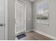 Bright entryway with a window, wood look flooring, and a door with privacy blinds at 444 49Th N St, St Petersburg, FL 33710